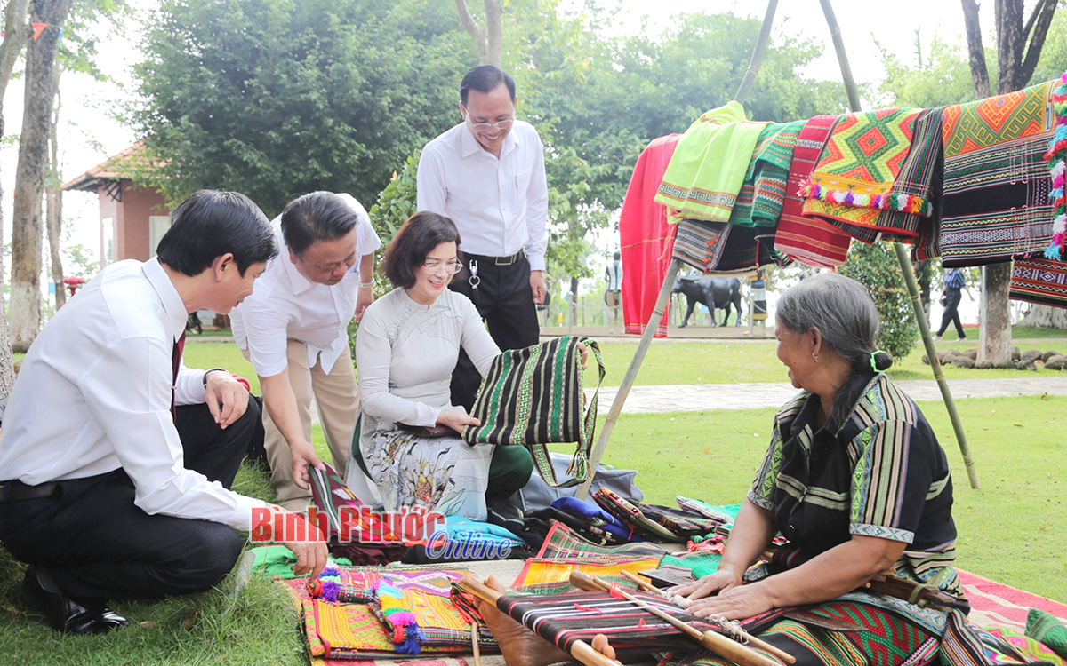 Ủy viên Ban Thường vụ Tỉnh ủy, Phó Chủ tịch UBND tỉnh Trần Tuyết Minh và các đại biểu tham quan sản phẩm dệt thổ cẩm của đồng bào M’nông