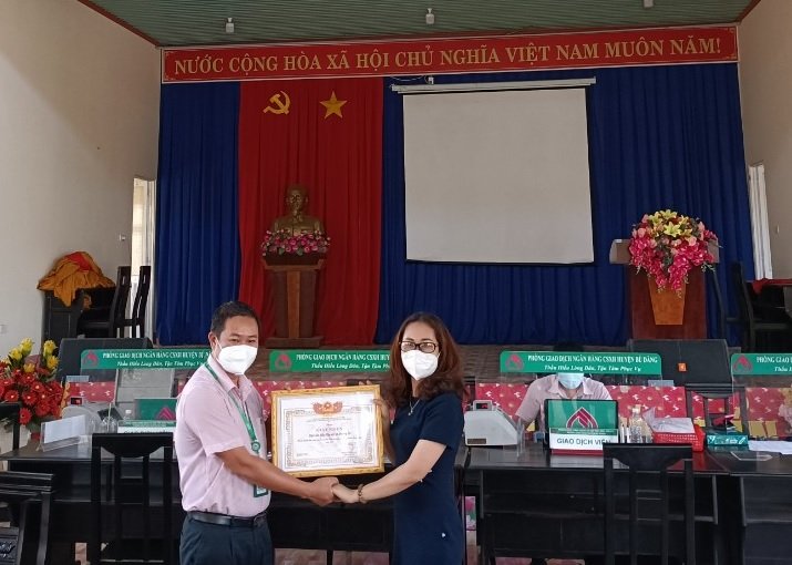 Ông Hoàng Quốc Việt - Phó Giám đốc NHCSXH huyện trao giấy khen của Trưởng Ban đại diện cho Hội Liên hiệp Phụ nữ xã Đường 10.